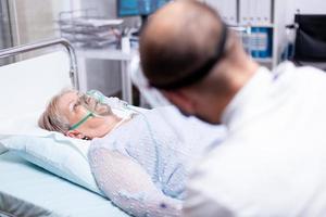 mulher idosa respirando com máscara de oxigênio foto