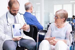 médico explicando o diagnóstico para uma mulher idosa foto