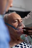 vista lateral da respiração do paciente idoso assistida por tubo respiratório foto