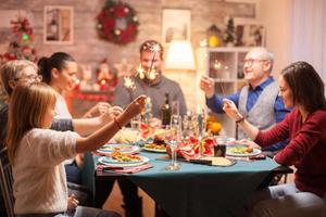 homem sênior alegre em jantar de natal em família foto