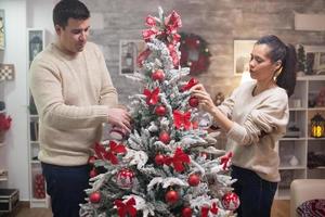 lindo casal caucasiano preparando sua árvore de natal