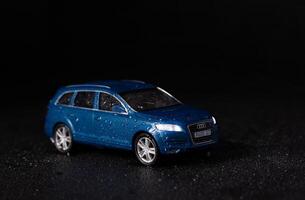 pode 20, 2020 Kyiv, Ucrânia. miniatura modelo do uma azul suv carro audi q7 em uma Preto fundo com água gotas foto