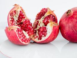 fruta de romã madura em um prato de porcelana wite foto