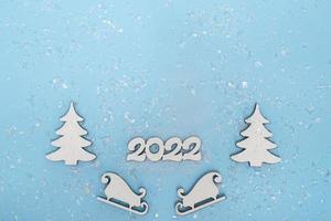 banner de feliz Natal e feliz ano novo. cartaz festivo com uma árvore de Natal, trenós e neve sobre um fundo azul. ano novo 2022 cópia espaço close up foto
