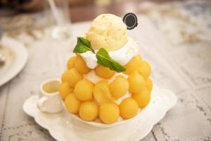 sobremesa bingsu, fruta bingsu melão com menu de creme de leite comer refrescante doce gelado servido na mesa comida coréia foto