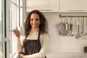 mulher latina tomando café na cozinha foto