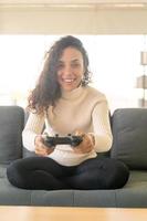 mulher laitin jogando videogame com as mãos segurando um joystick foto