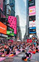 cidade de nova york, eua - 21 de junho de 2016. pessoas na concentração anual de ioga no solstício de verão na times square, símbolo icônico da cidade de nova york foto