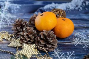 tangerinas em um fundo cinza com galhos de uma árvore de Natal, ao fundo uma janela com neve. conceito de ano novo. foto