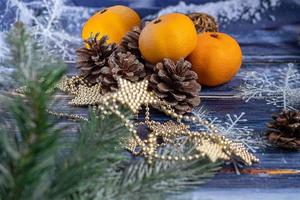 tangerinas em um fundo cinza com galhos de uma árvore de Natal, ao fundo uma janela com neve. conceito de ano novo.