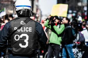 Montreal, Canadá, 02 de abril de 2015 - detalhe das costas de uma polícia enfrentando os manifestantes. foto