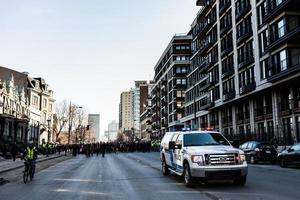 Montreal, Canadá, 02 de abril de 2015 - caminhonete da polícia em frente aos manifestantes controlando o trânsito foto