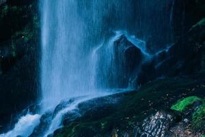 água azul bela cachoeira na floresta verde e pedra na selva consistem em água foto