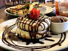 pão com calda de chocolate, frutas e sorvete em um prato foto