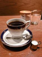 café preto em uma xícara branca sobre uma mesa de madeira foto