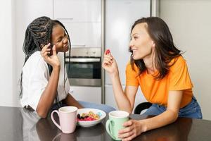 dois amigos fazendo um lanche saudável enquanto conversam em casa foto