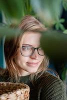 retrato de uma jovem cuidando das plantas em casa foto