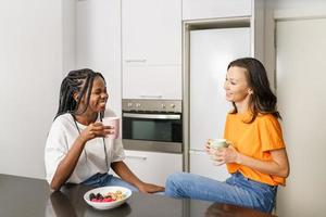 dois amigos fazendo um lanche saudável enquanto conversam em casa foto