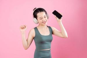 retrato de menina asiática fitness, isolado em um fundo rosa foto