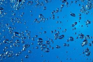 Resumo de respingo de onda de água transparente azul com bolhas de água no azul. foto