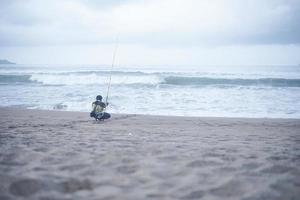 um jovem está pescando em um pântano com um dispositivo teatral. um hobby de pesca e preservação da natureza foto