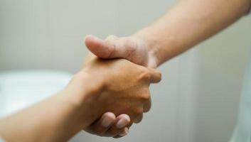 mãos se apertando, geralmente feito no início da reunião para cumprimentar um ao outro ou se apresentar. foto