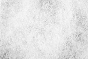 a visão detalhada do algodão artificial em branco. a textura irregular do material sintético para um padrão de fundo. foto