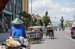 ponorogo, indonésia 2021 - homem dirige pedicab com passageiro foto