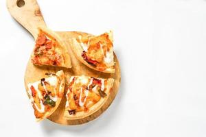 algumas fatias de pizza na pá de madeira em branco. uma comida italiana assada com cobertura tentadora para propaganda ou design de elementos. foto