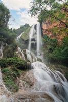 Cachoeira de erawan no 7º andar com água fluindo na floresta tropical do parque nacional foto