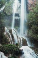 Cachoeira de erawan no 7º andar com água fluindo na floresta tropical do parque nacional foto