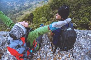 Amantes asiáticos mulheres e homens viajam pela natureza. viajar relaxar. sente-se e observe a vista da montanha. em um penhasco na montanha. Tailândia foto