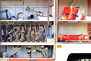 mangueiras de incêndio, válvulas e guindastes, cones de trânsito estão localizados no compartimento de carga de um caminhão de bombeiros equipado. foto