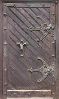 portas de madeira antigas antigas com laços de ferro forjado e barras transversais. foto