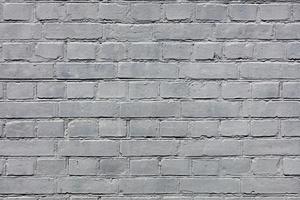 uma parede de tijolos muito antiga totalmente pintada com tinta cinza. foto