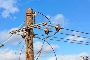 um poste antigo com fios elétricos e corrente trifásica. foto