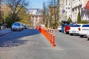 colunas de estrada laranja cortam a faixa de rodagem em um dia ensolarado de primavera. foto