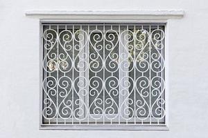 moldura figurada da janela com grade de ferro forjado branco foto