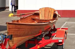 uma canoa de madeira laranja repousa em um estacionamento perto do escritório de trabalho. foto