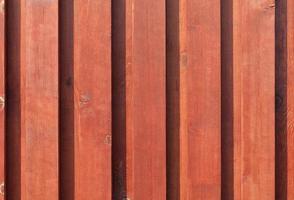 nova cerca de madeira marrom-vermelha nos raios de sol. foto