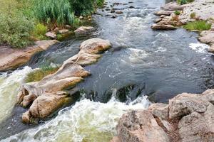 um riacho de água fervente entre as corredeiras de pedra do fluxo rápido do rio. foto