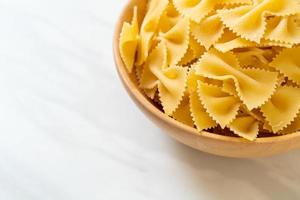 macarrão farfalle seco e cru na tigela foto