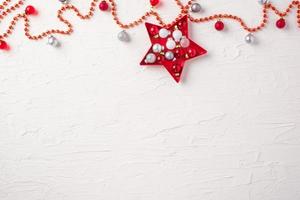 bola de natal e enfeites de decoração com estrelas no fundo branco da mesa de concreto foto