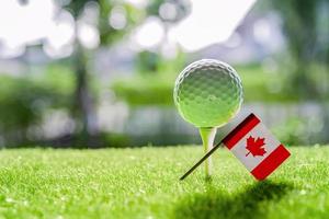 Bola mundial de golfe com a bandeira do Canadá em gramado ou campo verde, o esporte mais popular do mundo. foto