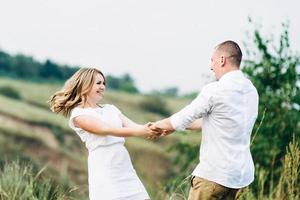 um cara com uma garota em roupas leves no fundo de um desfiladeiro verde foto