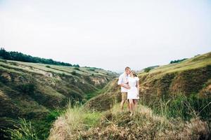 um cara com uma garota em roupas leves no fundo de um desfiladeiro verde foto