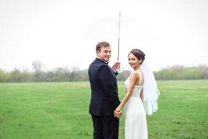 noiva e noivo em um dia chuvoso de casamento caminhando foto