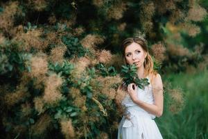 garota feliz em um vestido longo turquesa em um parque verde foto