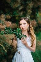 garota feliz em um vestido longo turquesa em um parque verde foto