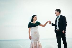o noivo em um terno marrom e a noiva em um vestido marfim foto